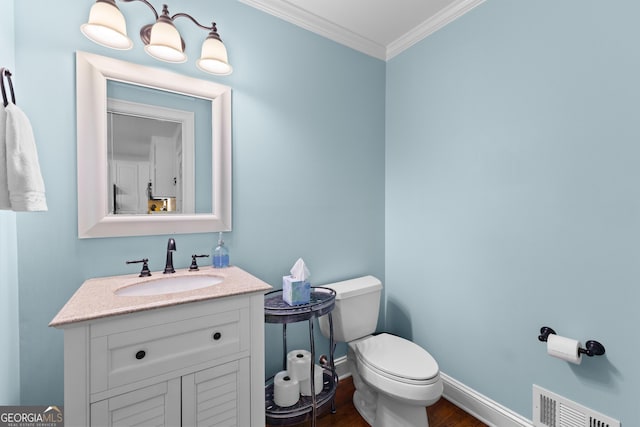 bathroom with toilet, wood finished floors, visible vents, crown molding, and baseboards