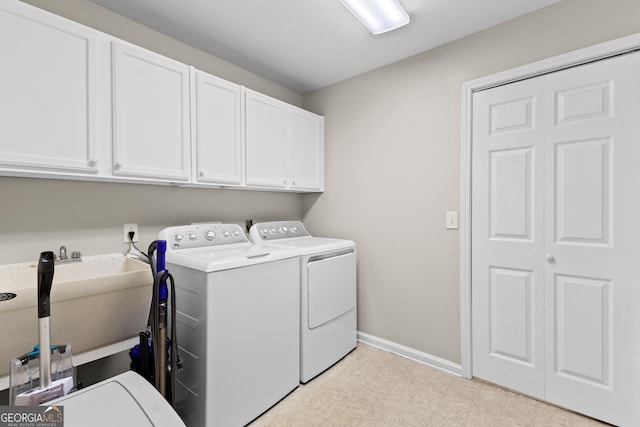 laundry area featuring cabinet space, independent washer and dryer, light floors, and baseboards