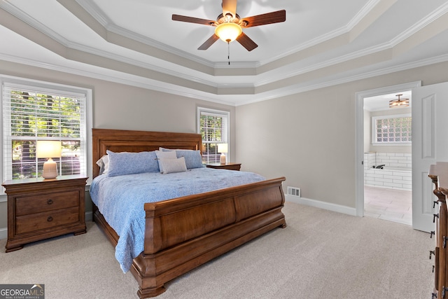 bedroom with multiple windows, light carpet, and a tray ceiling