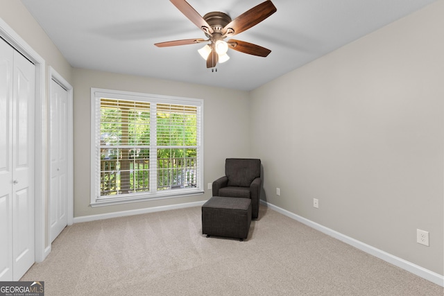 living area featuring ceiling fan, carpet floors, and baseboards