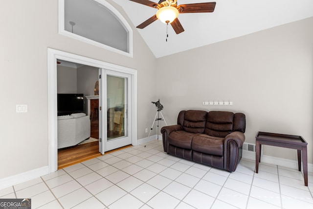 living area featuring light tile patterned floors, a ceiling fan, baseboards, and lofted ceiling