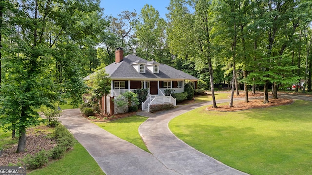 view of front of property with covered porch, aphalt driveway, and a front yard