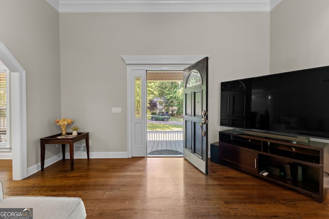 entryway featuring baseboards, ornamental molding, and wood finished floors