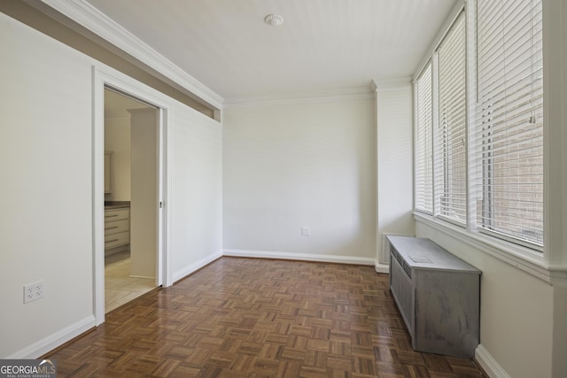 spare room featuring baseboards and crown molding