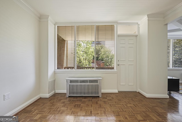 empty room with radiator heating unit, baseboards, and crown molding