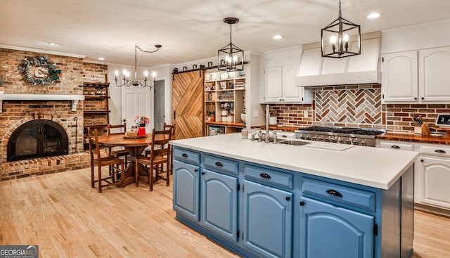 2244 Deer Ridge Dr, Tucker, GA 30087 - kitchen with blue cabinets, a chandelier, white cabinetry, ornamental molding, and recessed lighting