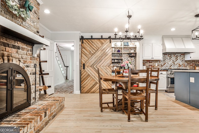 2244 Deer Ridge Dr, Tucker, GA 30087 - dining space featuring light wood-style flooring, a chandelier, ornamental molding, stairs, and a barn door