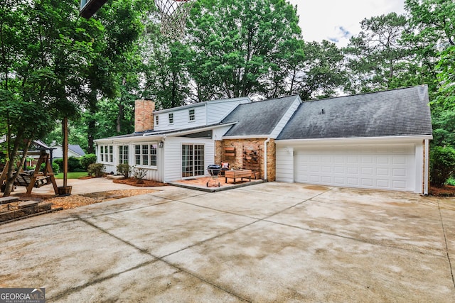 2244 Deer Ridge Dr, Tucker, GA 30087 - view of front of house with concrete driveway, a shingled roof, a garage, brick siding, and a chimney