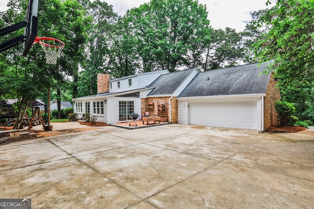 2244 Deer Ridge Dr, Tucker, GA 30087 - view of front of property with concrete driveway, a garage, brick siding, and a chimney