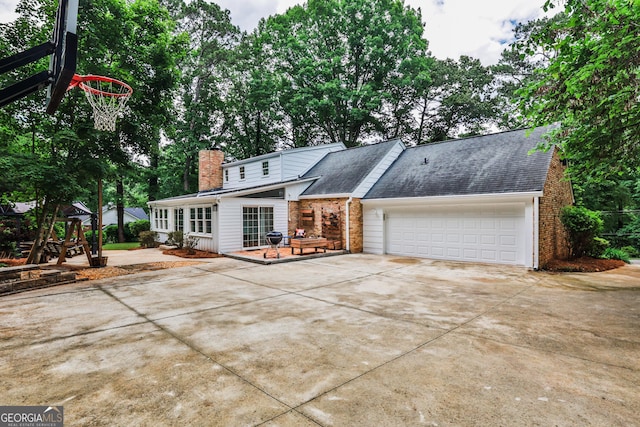 2244 Deer Ridge Dr, Tucker, GA 30087 - view of front of house with concrete driveway, an attached garage, brick siding, a chimney, and roof with shingles