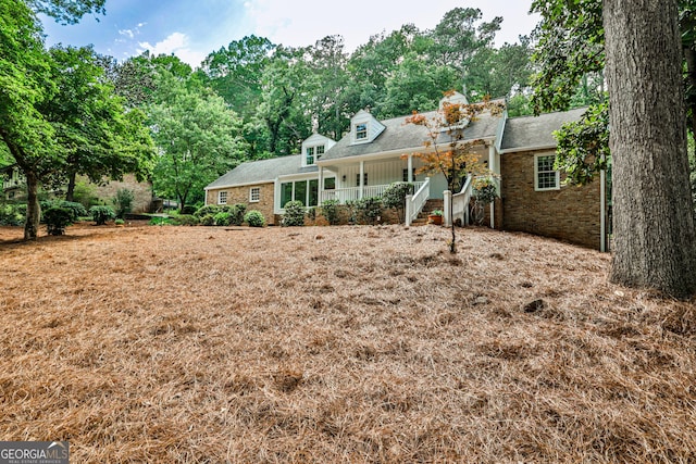 2244 Deer Ridge Dr, Tucker, GA 30087 - back of house with covered porch, a chimney, brick siding, and roof with shingles
