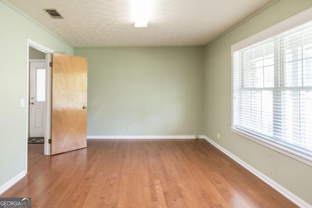 1114 Laurel St, Blackshear, GA 31516 - spare room with visible vents, wood finished floors, and a healthy amount of sunlight