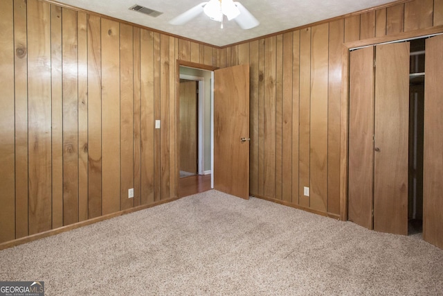 1114 Laurel St, Blackshear, GA 31516 - unfurnished bedroom with carpet, a ceiling fan, a closet, visible vents, and wooden walls