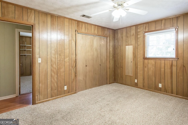 1114 Laurel St, Blackshear, GA 31516 - unfurnished bedroom featuring a closet, visible vents, wooden walls, and carpet floors