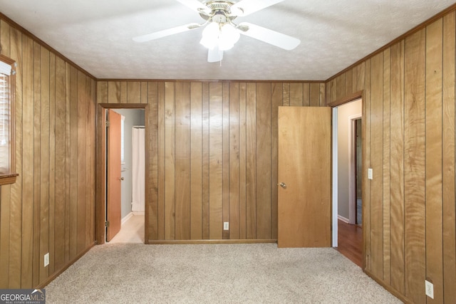 1114 Laurel St, Blackshear, GA 31516 - unfurnished bedroom with wooden walls, ceiling fan, and carpet floors