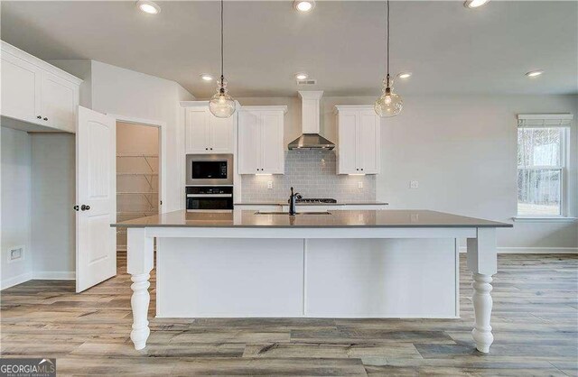 512 Dolce Rd, Locust Grove, GA 30248 - kitchen with a sink, stainless steel microwave, baseboards, wall oven, and wall chimney range hood