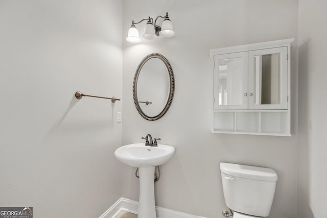 bathroom featuring toilet and baseboards