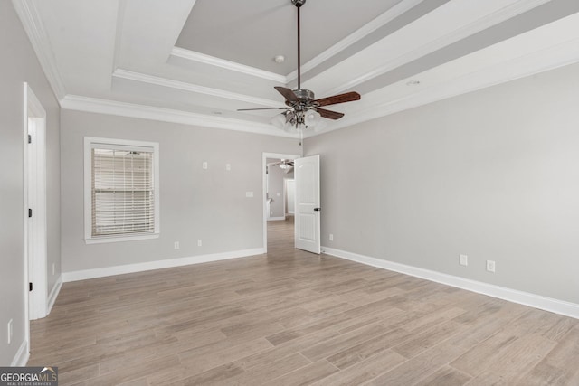 unfurnished bedroom with baseboards, ornamental molding, light wood finished floors, ceiling fan, and a raised ceiling