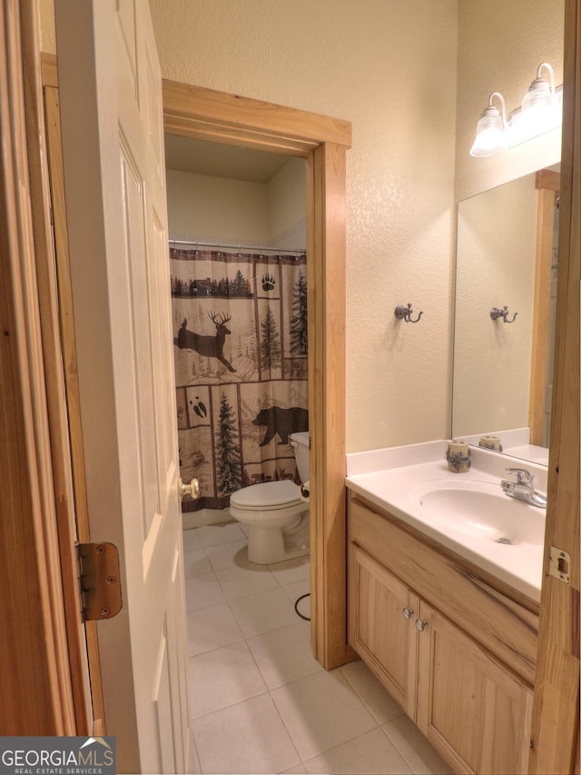 full bathroom with toilet, a shower with curtain, vanity, tile patterned floors, and a textured wall