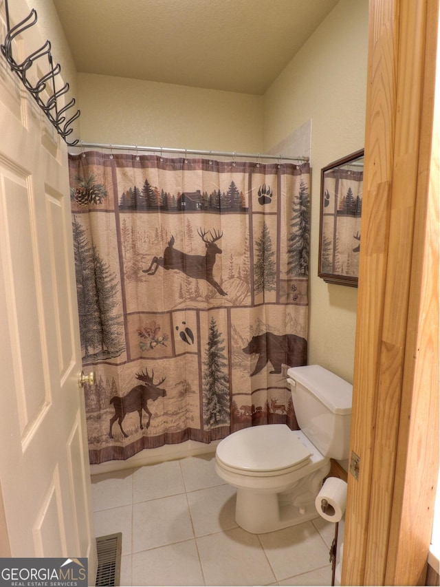 full bath featuring tile patterned floors, toilet, visible vents, and curtained shower