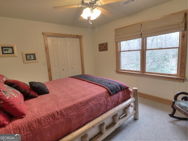 bedroom with a closet, carpet floors, visible vents, baseboards, and ceiling fan