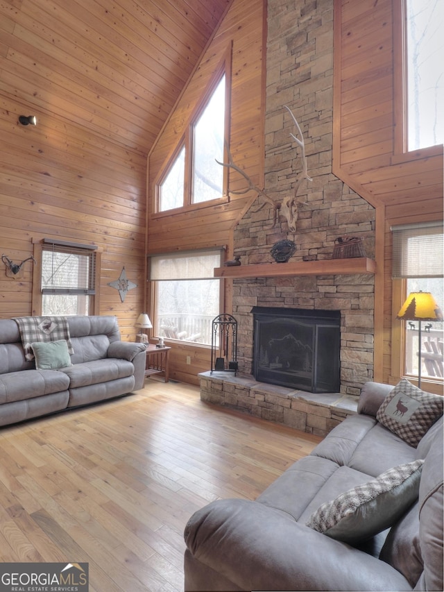 living room with wood-type flooring, a healthy amount of sunlight, and high vaulted ceiling