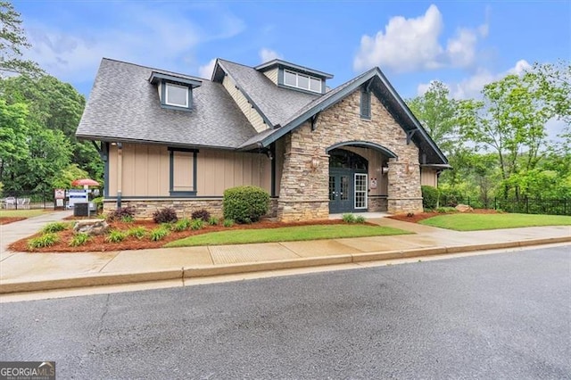 craftsman-style home featuring stone siding, board and batten siding, and a shingled roof