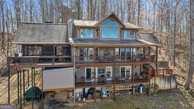 back of house featuring a shingled roof, stairway, a wooden deck, and cooling unit