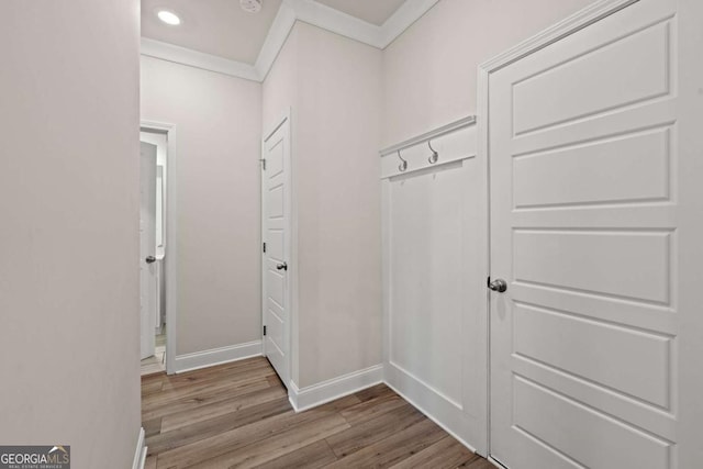 interior space with crown molding, wood finished floors, baseboards, and recessed lighting