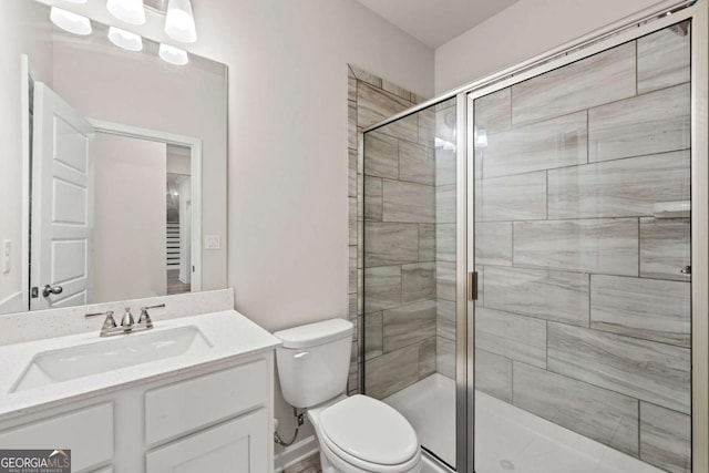 bathroom featuring vanity, toilet, and a stall shower