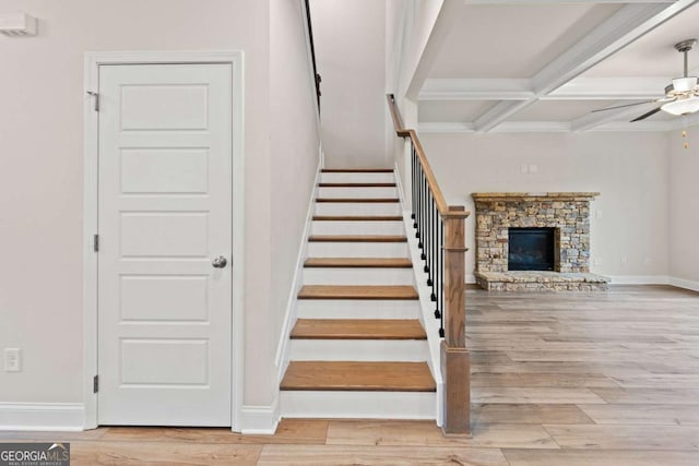 stairs featuring coffered ceiling, baseboards, ceiling fan, wood finished floors, and beam ceiling