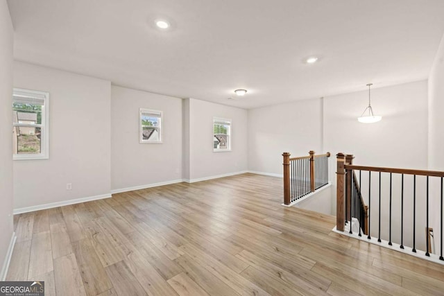 unfurnished room with light wood finished floors, baseboards, and recessed lighting