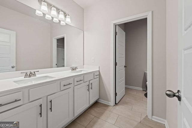 full bath featuring a sink, double vanity, toilet, and tile patterned flooring