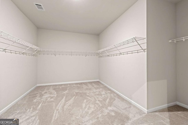 walk in closet featuring visible vents and carpet floors
