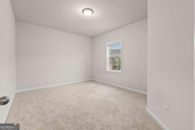 spare room featuring carpet and baseboards