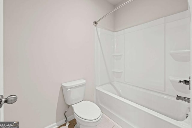 bathroom with shower / bathing tub combination, toilet, baseboards, and tile patterned floors
