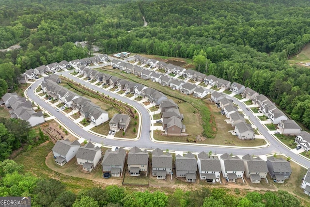 drone / aerial view with a wooded view and a residential view