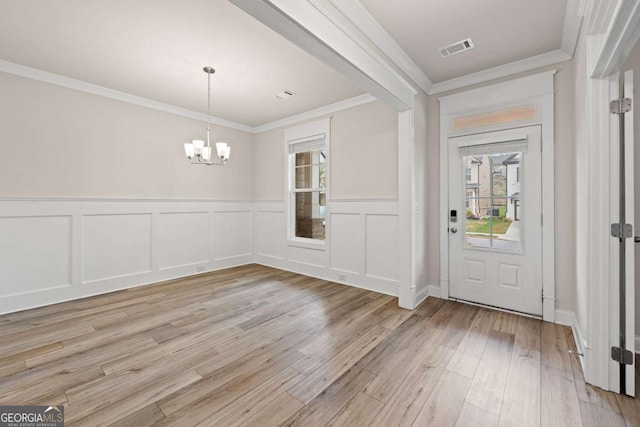 entrance foyer with light wood-style flooring, a chandelier, and plenty of natural light