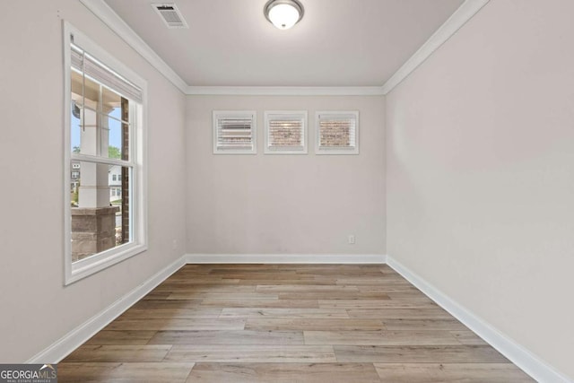 empty room with ornamental molding, baseboards, and visible vents