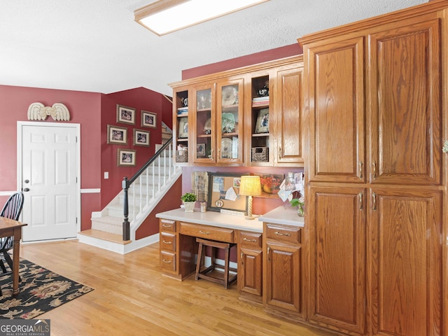 home office with baseboards and light wood-type flooring