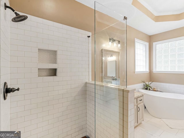 bathroom featuring tile patterned flooring, a raised ceiling, tiled shower, and a freestanding tub