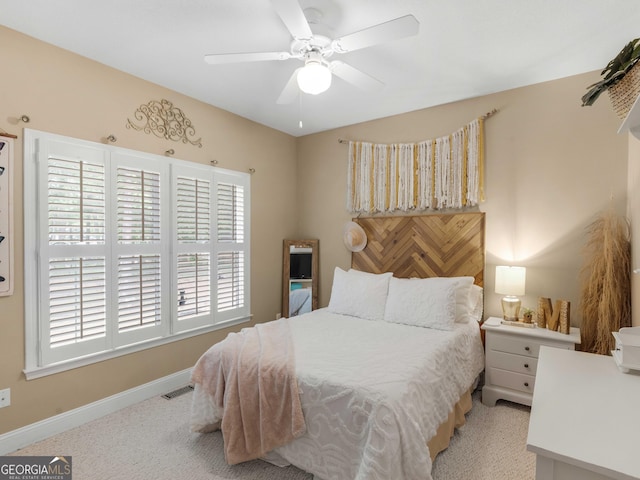 bedroom with baseboards, carpet flooring, visible vents, and a ceiling fan