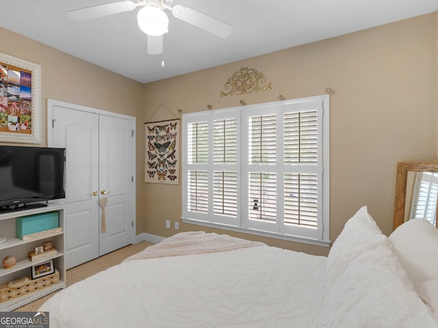 carpeted bedroom featuring a closet, baseboards, and ceiling fan