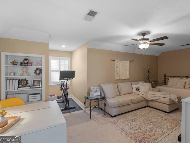 living room with light colored carpet, visible vents, baseboards, and ceiling fan