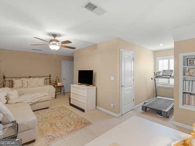 living room featuring light colored carpet, visible vents, baseboards, and ceiling fan