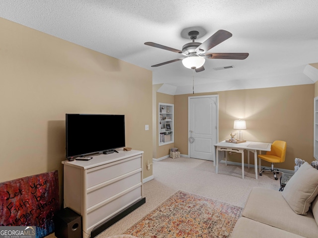 living area featuring a textured ceiling, visible vents, baseboards, ceiling fan, and light colored carpet