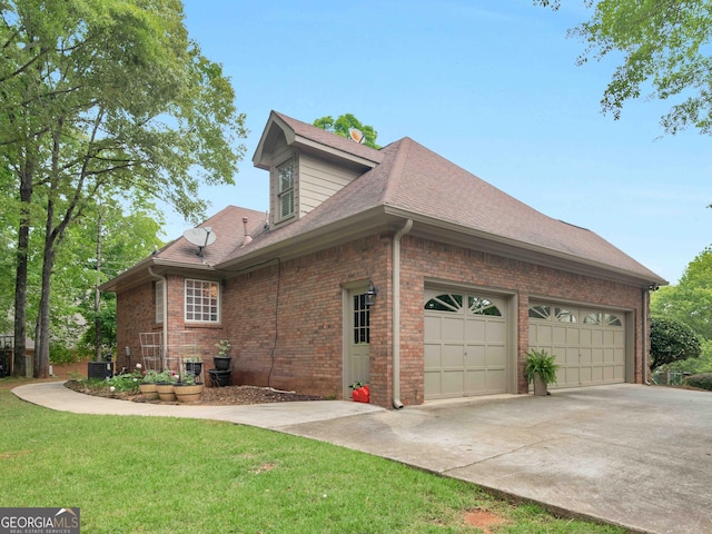 view of property exterior with a garage, a yard, a shingled roof, brick siding, and driveway