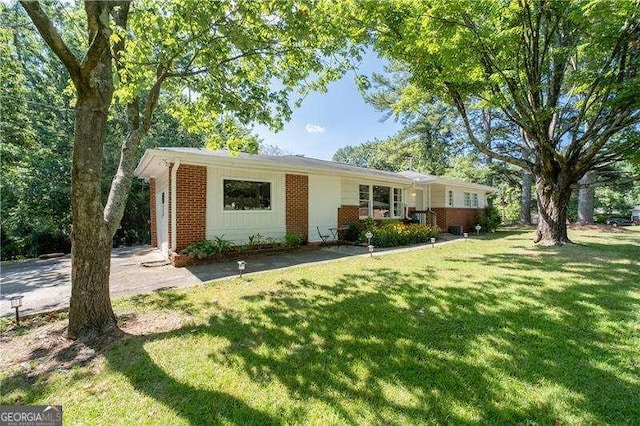 ranch-style house featuring a front lawn and brick siding