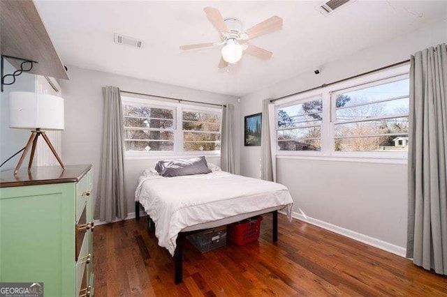 bedroom featuring wood finished floors, visible vents, baseboards, and a ceiling fan