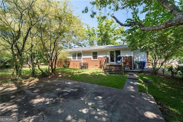 view of front facade featuring brick siding, fence, and a front yard